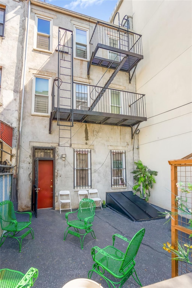 2370 Atlantic Ave, Brooklyn, NY 11233 - rear view of house with stucco siding, a balcony, and a patio area