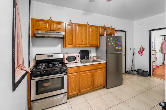 2370 Atlantic Ave, Brooklyn, NY 11233 - kitchen with appliances with stainless steel finishes, under cabinet range hood, light countertops, brown cabinetry, and light tile patterned floors