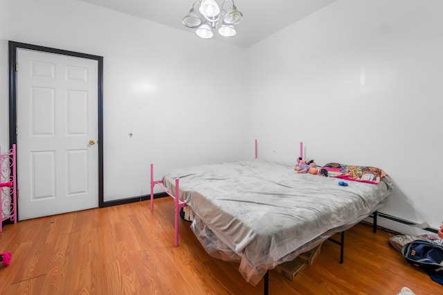 2370 Atlantic Ave, Brooklyn, NY 11233 - bedroom featuring a baseboard radiator, a chandelier, and light wood finished floors