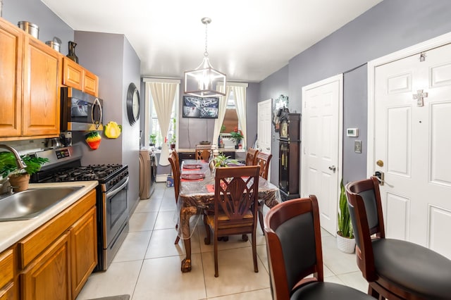 2370 Atlantic Ave, Brooklyn, NY 11233 - kitchen featuring appliances with stainless steel finishes, light countertops, hanging light fixtures, light tile patterned floors, and brown cabinetry