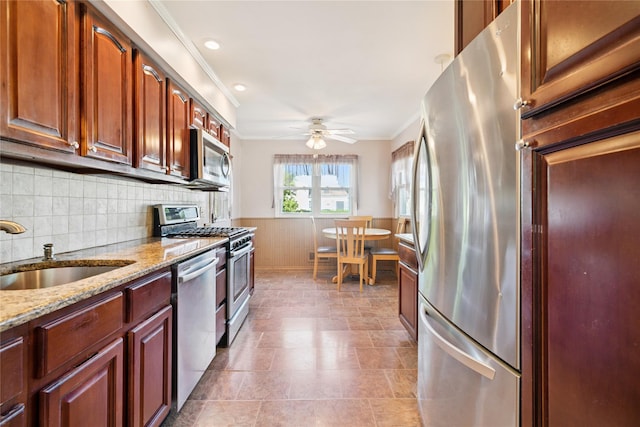 343 W 16th St, Deer Park, NY 11729 - kitchen featuring appliances with stainless steel finishes, ornamental molding, light stone countertops, ceiling fan, and a wainscoted wall