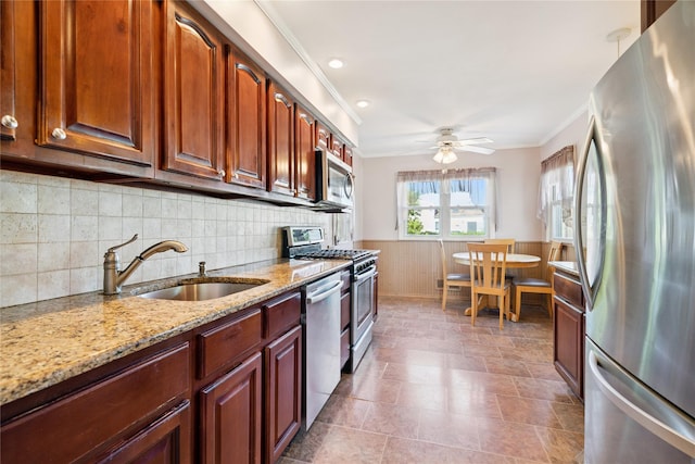 343 W 16th St, Deer Park, NY 11729 - kitchen with appliances with stainless steel finishes, crown molding, a wainscoted wall, light stone counters, and a ceiling fan