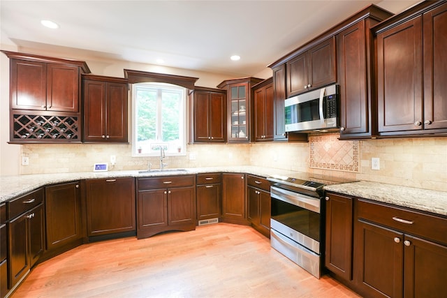 212 Weber Hill Rd, Carmel, NY 10512 - kitchen with appliances with stainless steel finishes, light wood-type flooring, light stone counters, decorative backsplash, and recessed lighting
