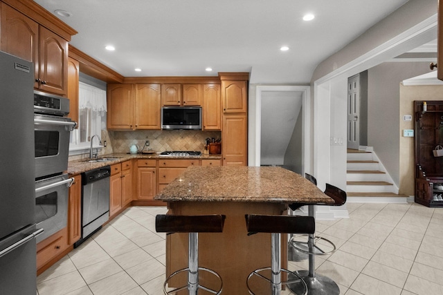 63 Bonnie Meadow Rd, Scarsdale, NY 10583 - kitchen featuring appliances with stainless steel finishes, stone counters, backsplash, a breakfast bar, and light tile patterned flooring