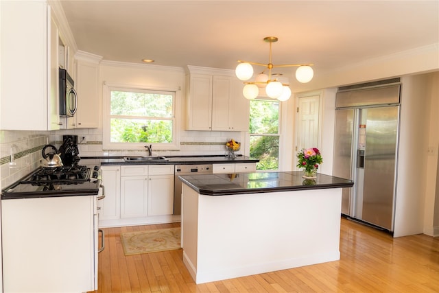 81 Seaview Ave, New Rochelle, NY 10801 - kitchen with stainless steel appliances, dark countertops, white cabinetry, and ornamental molding