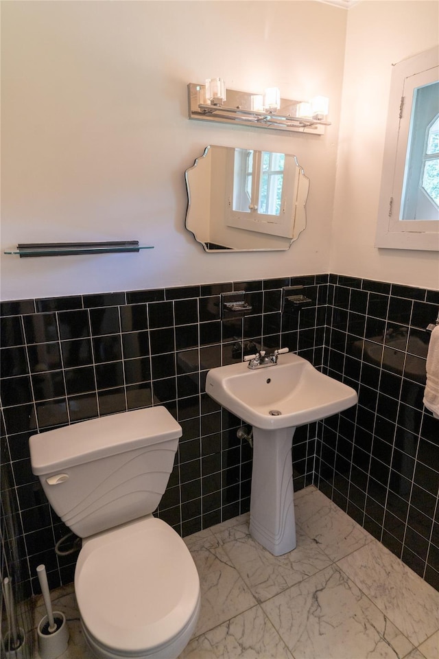 81 Seaview Ave, New Rochelle, NY 10801 - half bath featuring tile walls, a wainscoted wall, and marble look tiles