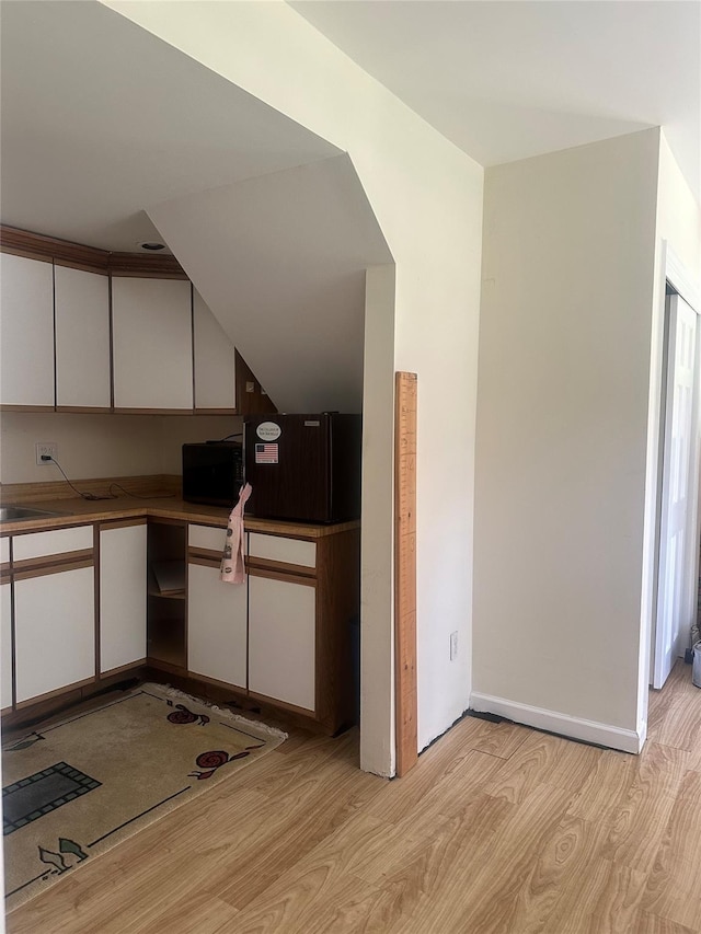 81 Seaview Ave, New Rochelle, NY 10801 - kitchen featuring light wood-style flooring, white cabinetry, and black microwave