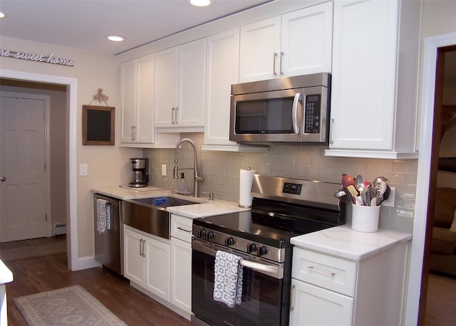68 Palmer Dr, Sayville, NY 11782 - kitchen with appliances with stainless steel finishes, white cabinets, decorative backsplash, dark wood finished floors, and recessed lighting