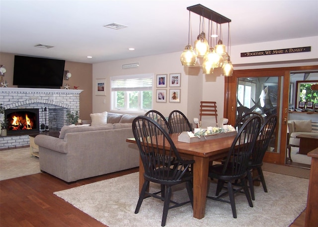 68 Palmer Dr, Sayville, NY 11782 - dining space featuring wood finished floors, a chandelier, a brick fireplace, and recessed lighting