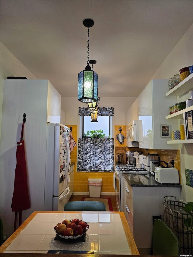 616 W 137th St Unit 1D, New York Manhattan, NY 10031 - kitchen featuring stainless steel gas range oven, freestanding refrigerator, dark countertops, open shelves, and decorative light fixtures