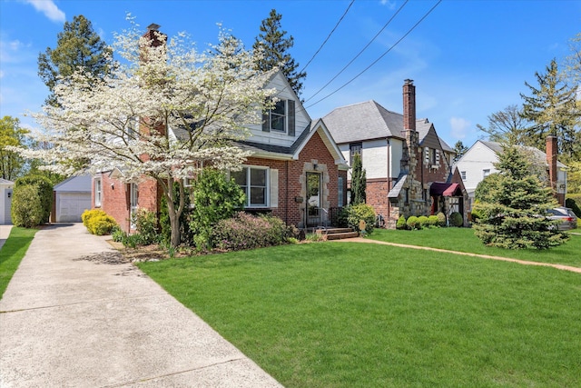 18 Hathaway Dr, Garden City, NY 11530 - tudor home featuring a chimney, brick siding, a front lawn, and a detached garage