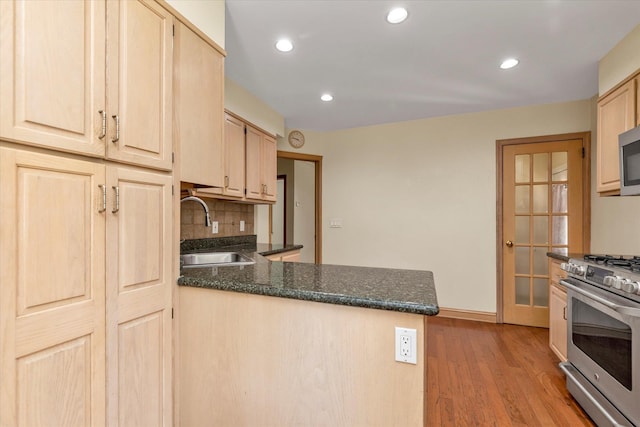18 Hathaway Dr, Garden City, NY 11530 - kitchen with stainless steel appliances, light brown cabinets, a peninsula, light wood-style flooring, and decorative backsplash