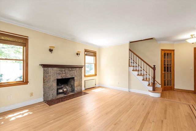 18 Hathaway Dr, Garden City, NY 11530 - unfurnished living room featuring radiator heating unit, wood finished floors, plenty of natural light, ornamental molding, and a fireplace