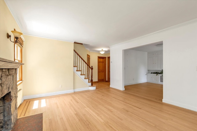 18 Hathaway Dr, Garden City, NY 11530 - unfurnished living room featuring a stone fireplace, crown molding, stairway, and light wood-type flooring