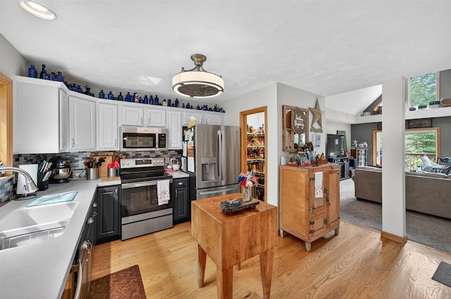 189 School House Rd, Middletown, NY 10940 - kitchen with appliances with stainless steel finishes, white cabinetry, light wood-type flooring, light countertops, and decorative backsplash
