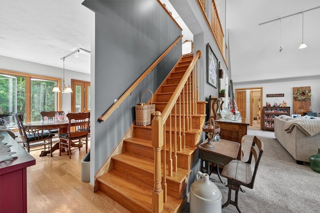 189 School House Rd, Middletown, NY 10940 - stairway featuring track lighting, a chandelier, and wood finished floors
