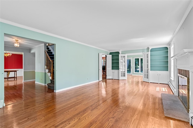 6 Beardsley Ln, Lloyd Harbor, NY 11743 - unfurnished living room with a glass covered fireplace, stairway, ornamental molding, wood finished floors, and french doors