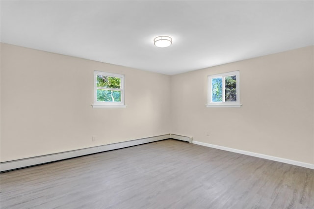 9 Rhodes Ln, West Hempstead, NY 11552 - empty room featuring healthy amount of natural light, baseboard heating, and wood finished floors