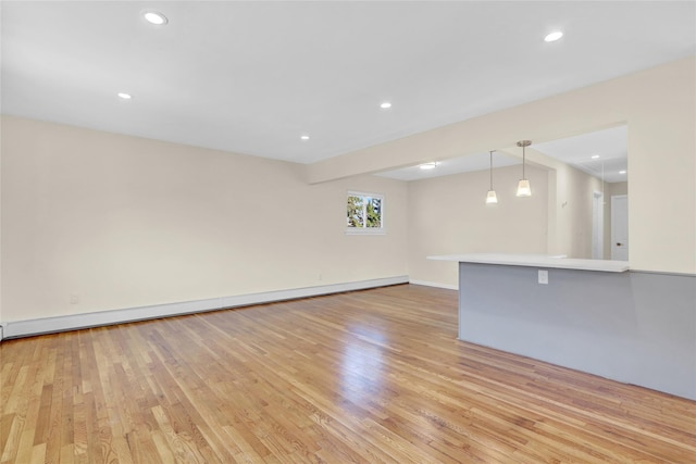 9 Rhodes Ln, West Hempstead, NY 11552 - unfurnished living room with a baseboard heating unit, light wood-style flooring, and recessed lighting