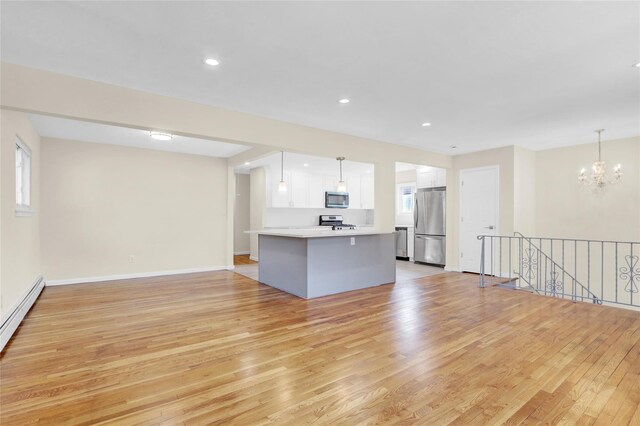 9 Rhodes Ln, West Hempstead, NY 11552 - unfurnished living room featuring light wood finished floors, a chandelier, a baseboard heating unit, and recessed lighting