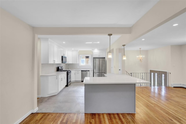 9 Rhodes Ln, West Hempstead, NY 11552 - kitchen with stainless steel appliances, light wood finished floors, light countertops, white cabinetry, and recessed lighting
