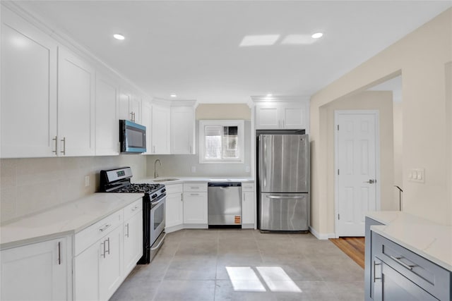 9 Rhodes Ln, West Hempstead, NY 11552 - kitchen with appliances with stainless steel finishes, white cabinetry, light stone counters, tasteful backsplash, and recessed lighting