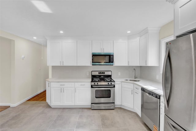 9 Rhodes Ln, West Hempstead, NY 11552 - kitchen featuring stainless steel appliances, light countertops, white cabinetry, recessed lighting, and light tile patterned floors