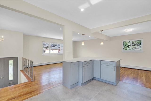 9 Rhodes Ln, West Hempstead, NY 11552 - kitchen with light countertops, hanging light fixtures, gray cabinets, beamed ceiling, and baseboard heating