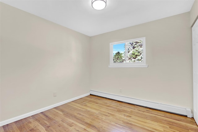 9 Rhodes Ln, West Hempstead, NY 11552 - empty room with a baseboard heating unit and wood finished floors