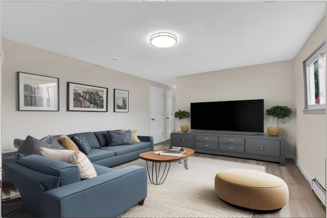 9 Rhodes Ln, West Hempstead, NY 11552 - living area featuring light wood-style flooring and a baseboard radiator