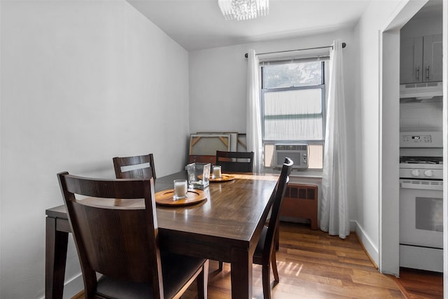 84 Spruce St Unit 1A, Yonkers, NY 10701 - dining space featuring radiator heating unit, cooling unit, wood finished floors, and a chandelier