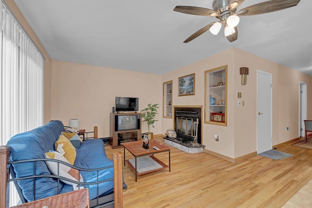 156 Creamery Rd Unit Tr20, Swan Lake, NY 12783 - living area featuring built in shelves, a glass covered fireplace, light wood-style flooring, and ceiling fan