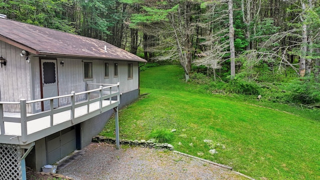 156 Creamery Rd Unit Tr20, Swan Lake, NY 12783 - view of grassy yard featuring gravel driveway, a view of trees, and an attached garage