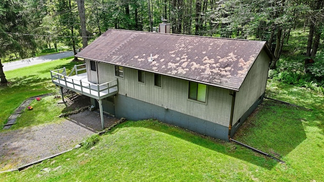 156 Creamery Rd Unit Tr20, Swan Lake, NY 12783 - view of home's exterior featuring a lawn, a deck, a shingled roof, and a chimney