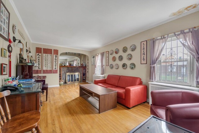 5802 201st St, Bayside, NY 11364 - living area featuring arched walkways, ornamental molding, light wood-type flooring, and a glass covered fireplace