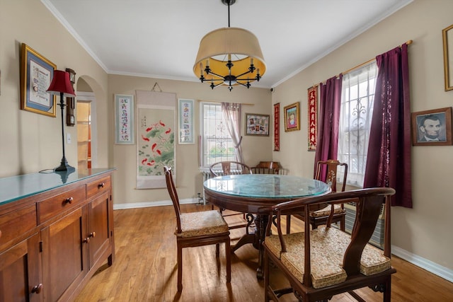 5802 201st St, Bayside, NY 11364 - dining space featuring light wood-style floors, healthy amount of natural light, crown molding, a chandelier, and arched walkways