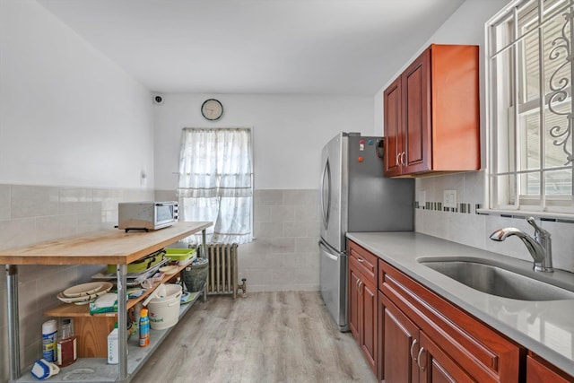 5802 201st St, Bayside, NY 11364 - kitchen featuring radiator heating unit, tile walls, light wood-style flooring, light countertops, and dark brown cabinets