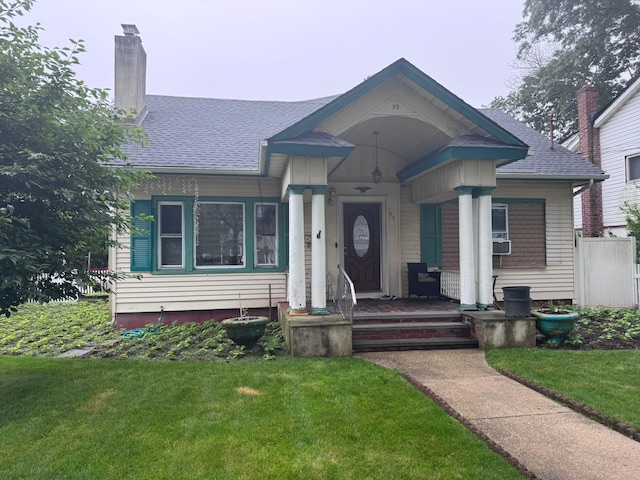 59 Ingraham Blvd, Hempstead, NY 11550 - bungalow-style home featuring a chimney, a front yard, and roof with shingles
