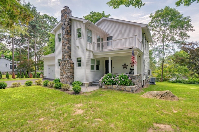 1299 Williams Dr, Shrub Oak, NY 10588 - view of front of home featuring a balcony, a chimney, a garage, a front lawn, and asphalt driveway