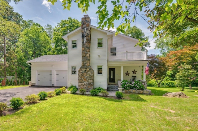 1299 Williams Dr, Shrub Oak, NY 10588 - view of front of house featuring a balcony, a chimney, asphalt driveway, an attached garage, and a front yard