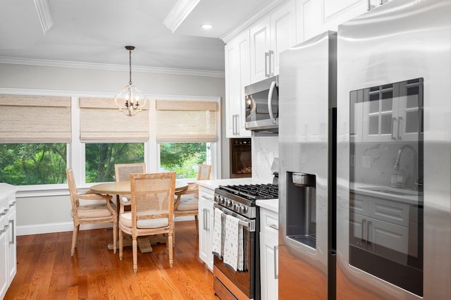 1299 Williams Dr, Shrub Oak, NY 10588 - kitchen featuring appliances with stainless steel finishes, ornamental molding, healthy amount of natural light, light countertops, and white cabinetry