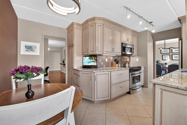 414 Benedict Ave Unit 5B, Tarrytown, NY 10591 - kitchen featuring stainless steel appliances, decorative backsplash, light stone countertops, light brown cabinets, and light tile patterned floors