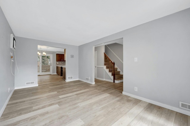 1138 Vincent Ave, Bronx, NY 10465 - spare room featuring a chandelier, stairway, and light wood finished floors
