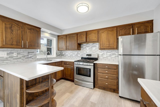 1138 Vincent Ave, Bronx, NY 10465 - kitchen featuring stainless steel appliances, light countertops, light wood-style flooring, backsplash, and a peninsula