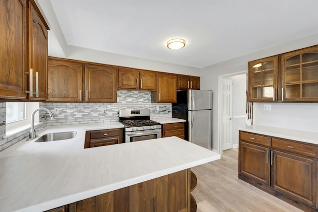 1138 Vincent Ave, Bronx, NY 10465 - kitchen with stainless steel appliances, decorative backsplash, light countertops, light wood-style floors, and glass insert cabinets