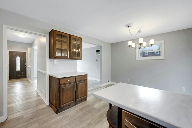 1138 Vincent Ave, Bronx, NY 10465 - kitchen featuring light wood-style flooring, glass insert cabinets, a chandelier, light countertops, and an AC wall unit