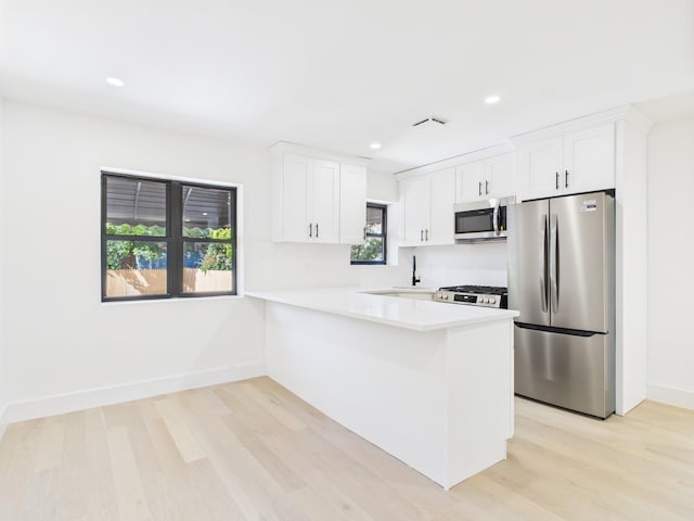 1310 E 223rd St, Bronx, NY 10466 - kitchen with stainless steel appliances, light wood-type flooring, light countertops, white cabinets, and recessed lighting