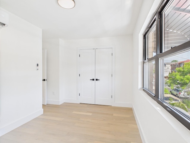 1310 E 223rd St, Bronx, NY 10466 - unfurnished bedroom featuring light wood-type flooring, a closet, and a wall unit AC