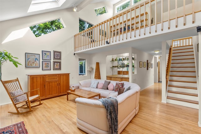 8 Braemer Rd, East Setauket, NY 11733 - living area with a skylight, wood finished floors, plenty of natural light, a towering ceiling, and stairway