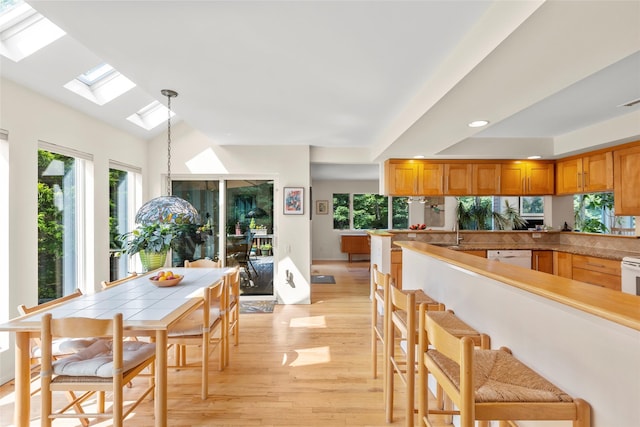 8 Braemer Rd, East Setauket, NY 11733 - kitchen featuring a skylight, light wood-style flooring, pendant lighting, light countertops, and recessed lighting